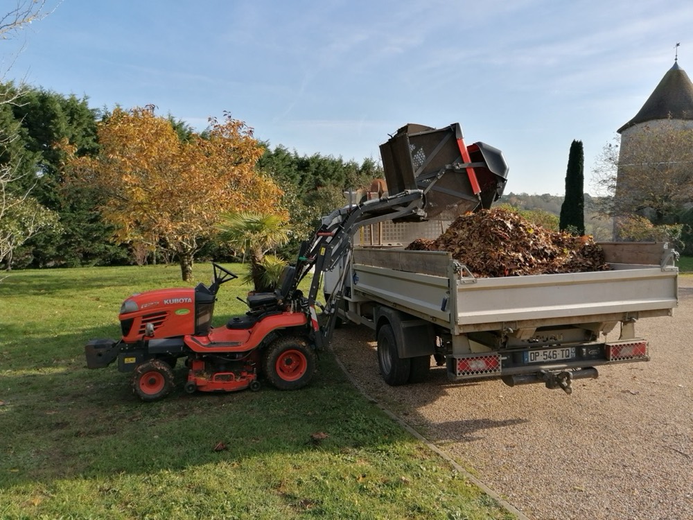 Tracteur-tondeuse qui vide les feuilles ramassées dans le camion benne